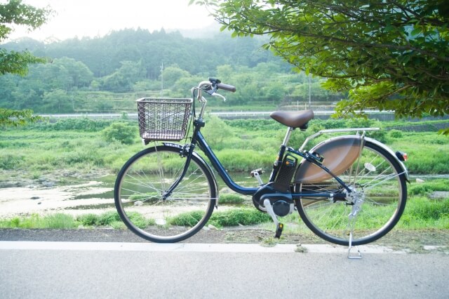 自然あふれる背景と電動自転車